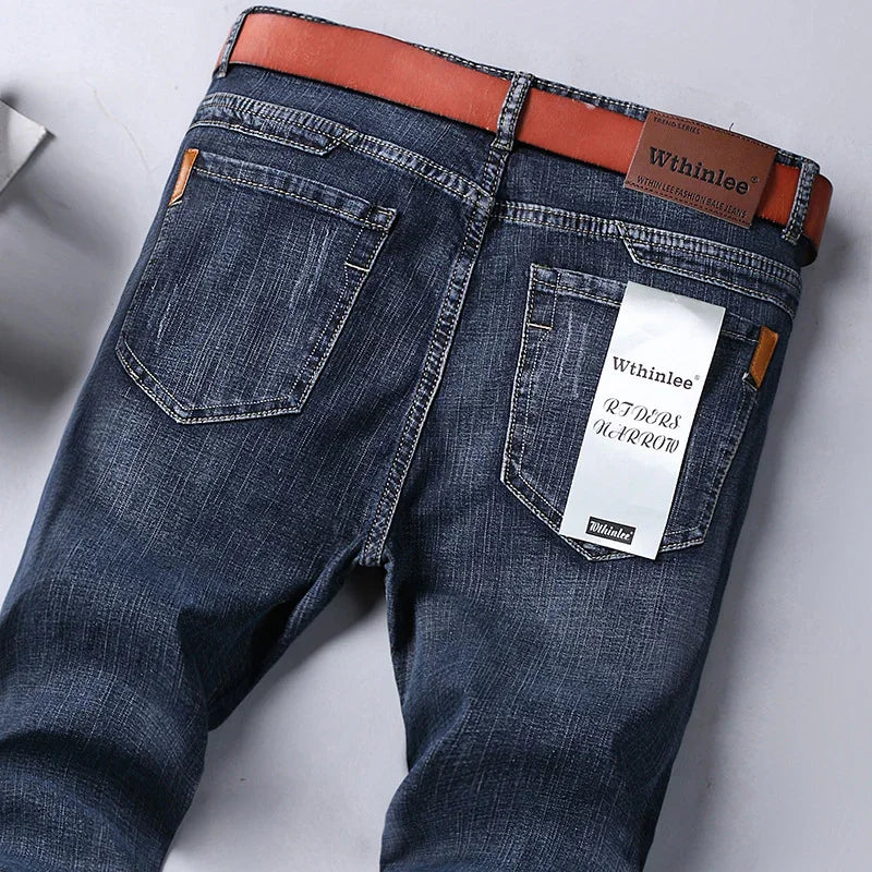 Dark blue denim jeans with brown belt and Wthinlee brand label on back pocket