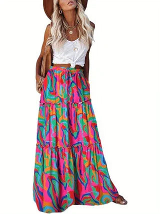 Woman wearing a white sleeveless top and a colorful psychedelic print tiered maxi skirt