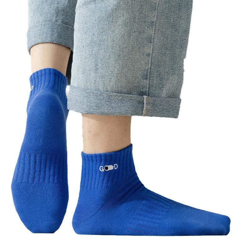 Blue ankle socks with ribbed cuffs and word 'GOOD' embroidered, worn with rolled-up light denim jeans