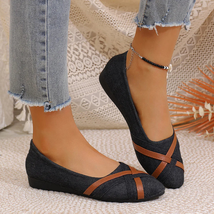 Black denim wedge flats with brown leather straps worn with frayed hem jeans and beaded anklet on woven rug