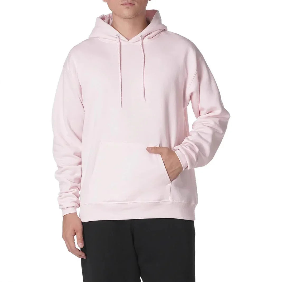 Man wearing light pink hoodie with pocket and drawstrings, paired with black pants, isolated on white