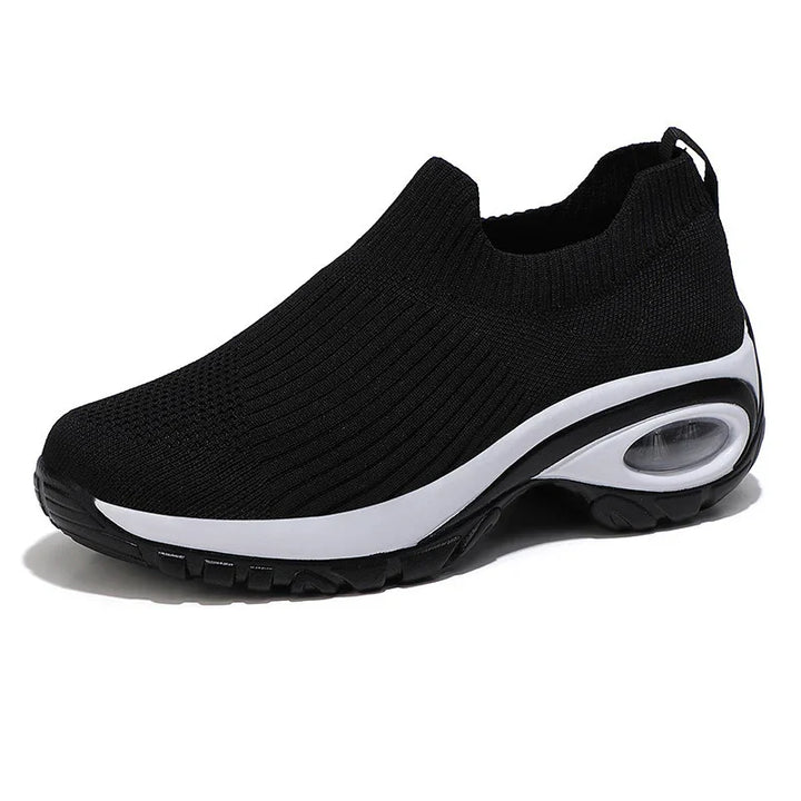 Black slip-on athletic sneaker with knit upper and white midsole featuring visible air cushion