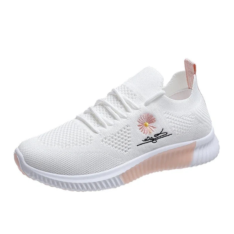 White knit sneaker with pink sole accent, laces, and floral embroidery detail on side