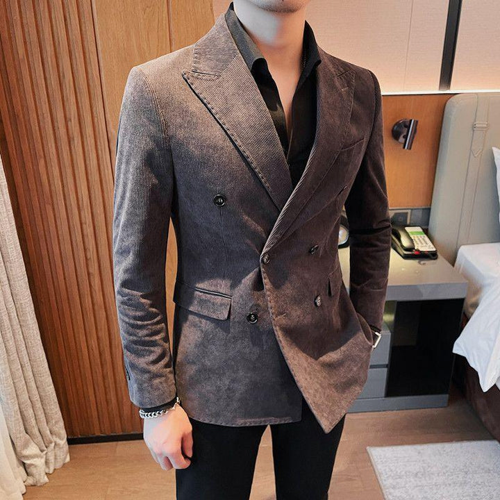Man wearing double-breasted brown corduroy blazer with black shirt in modern bedroom