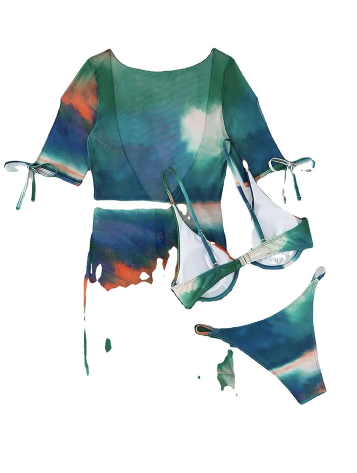 Colorful tie-dye bikini set and sheer cover-up with green, orange, and blue hues on white background
