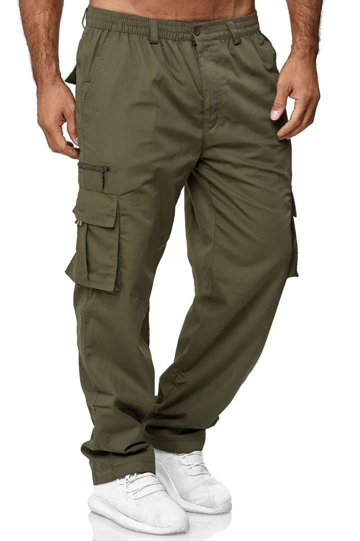 Men's olive green cargo pants with multiple pockets and white sneakers on model
