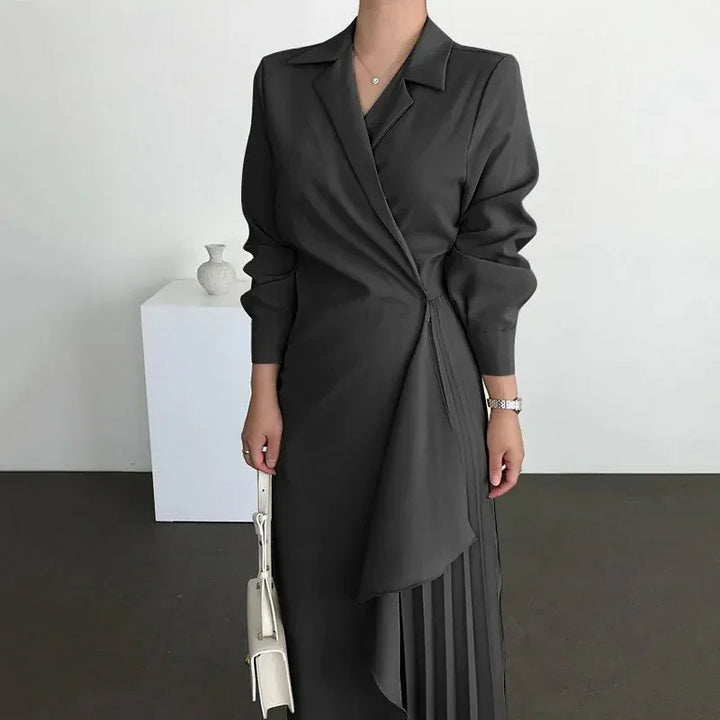 woman wearing stylish black wrap dress with pleated skirt detail holding white handbag