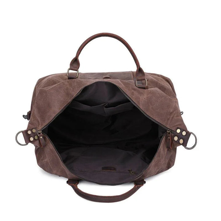 Open brown leather and canvas duffel bag with spacious black interior and sturdy handles