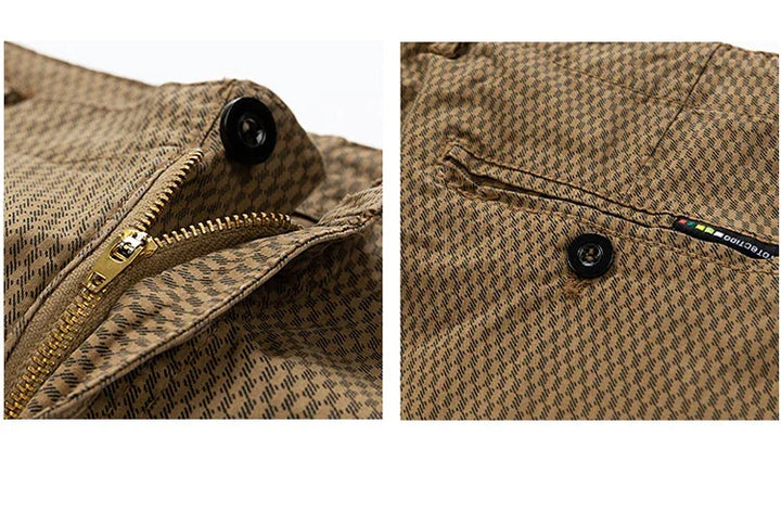 Close-up of brown patterned fabric pants with gold zipper, black button, and small label detail