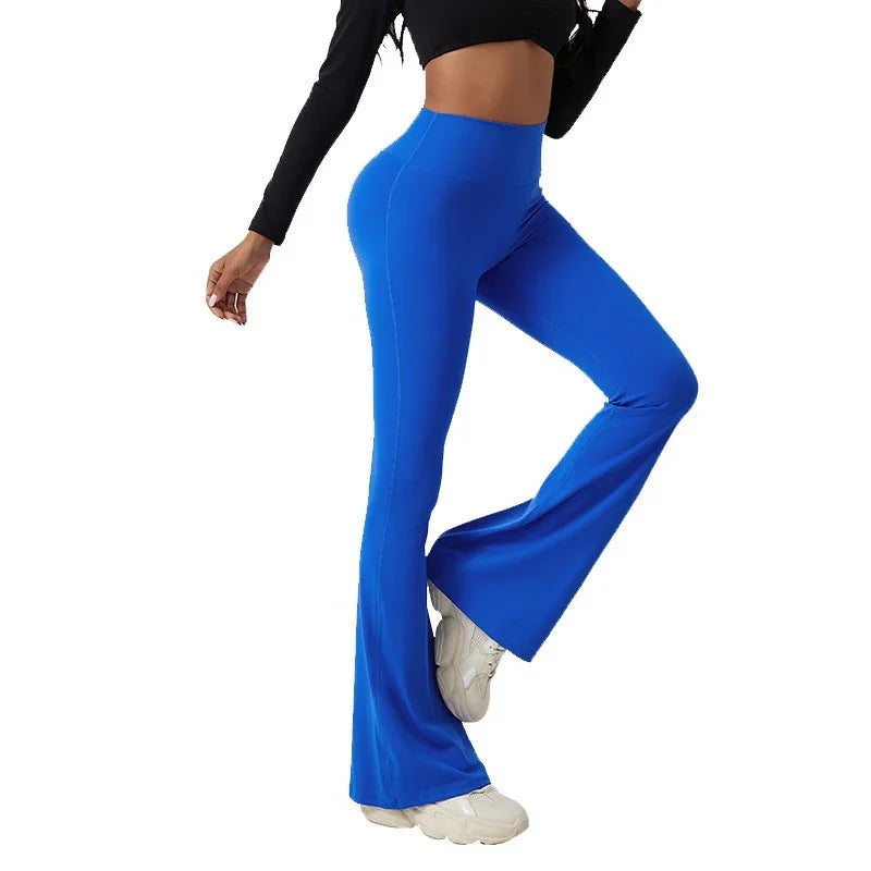 Woman wearing high-waisted bright blue flare leggings with white sneakers and a black crop top