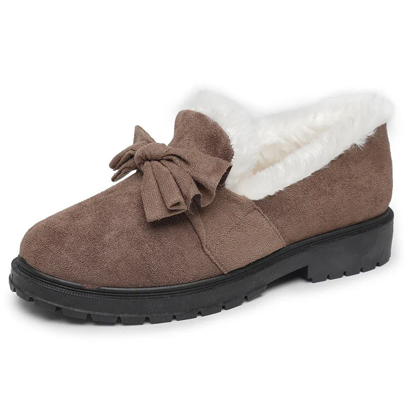 Brown suede slip-on shoe with bow detail and white faux fur lining, rubber sole