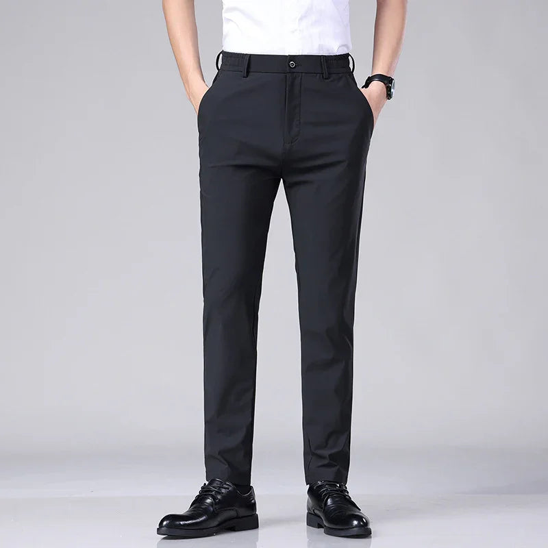 Men's black formal slim-fit trousers paired with black dress shoes and white shirt