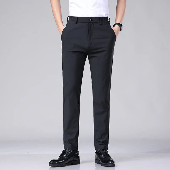 Men's black formal slim-fit trousers paired with black dress shoes and white shirt