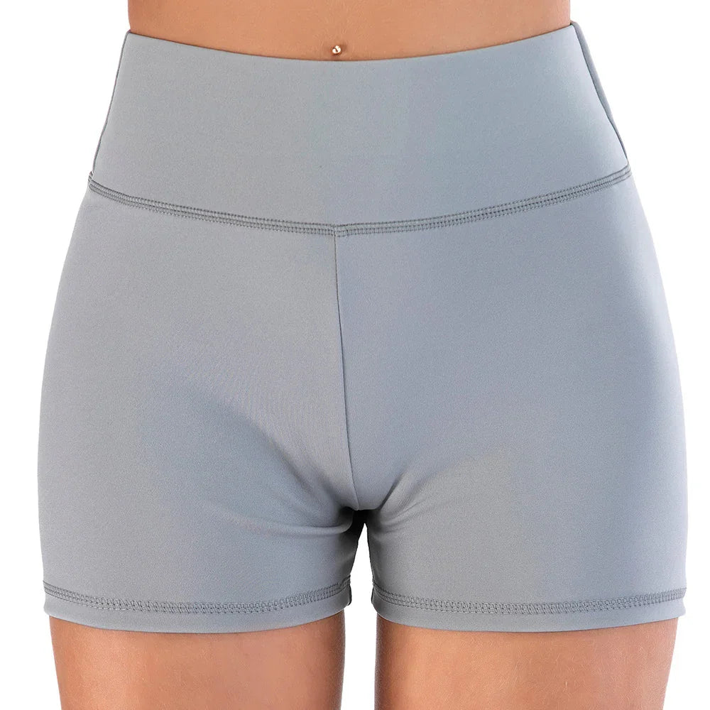 Close-up front view of high-waisted gray athletic shorts on a person with belly button piercing