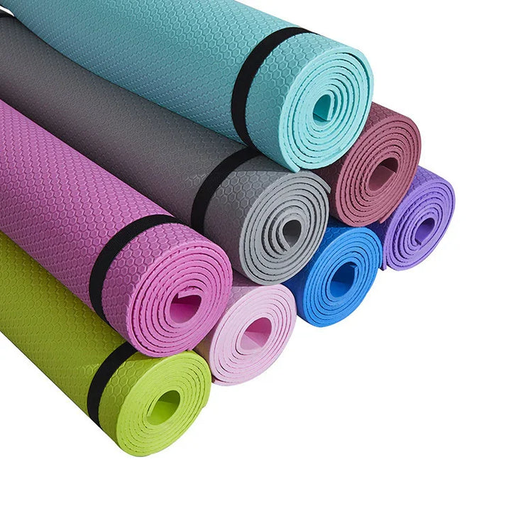 Stack of colorful textured yoga mats rolled up for fitness and exercise