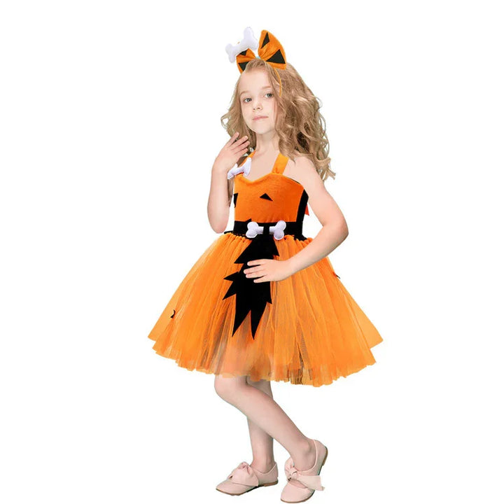 Little girl wearing an orange flintstones-inspired Halloween dress with bone accessories and tiger-striped bow