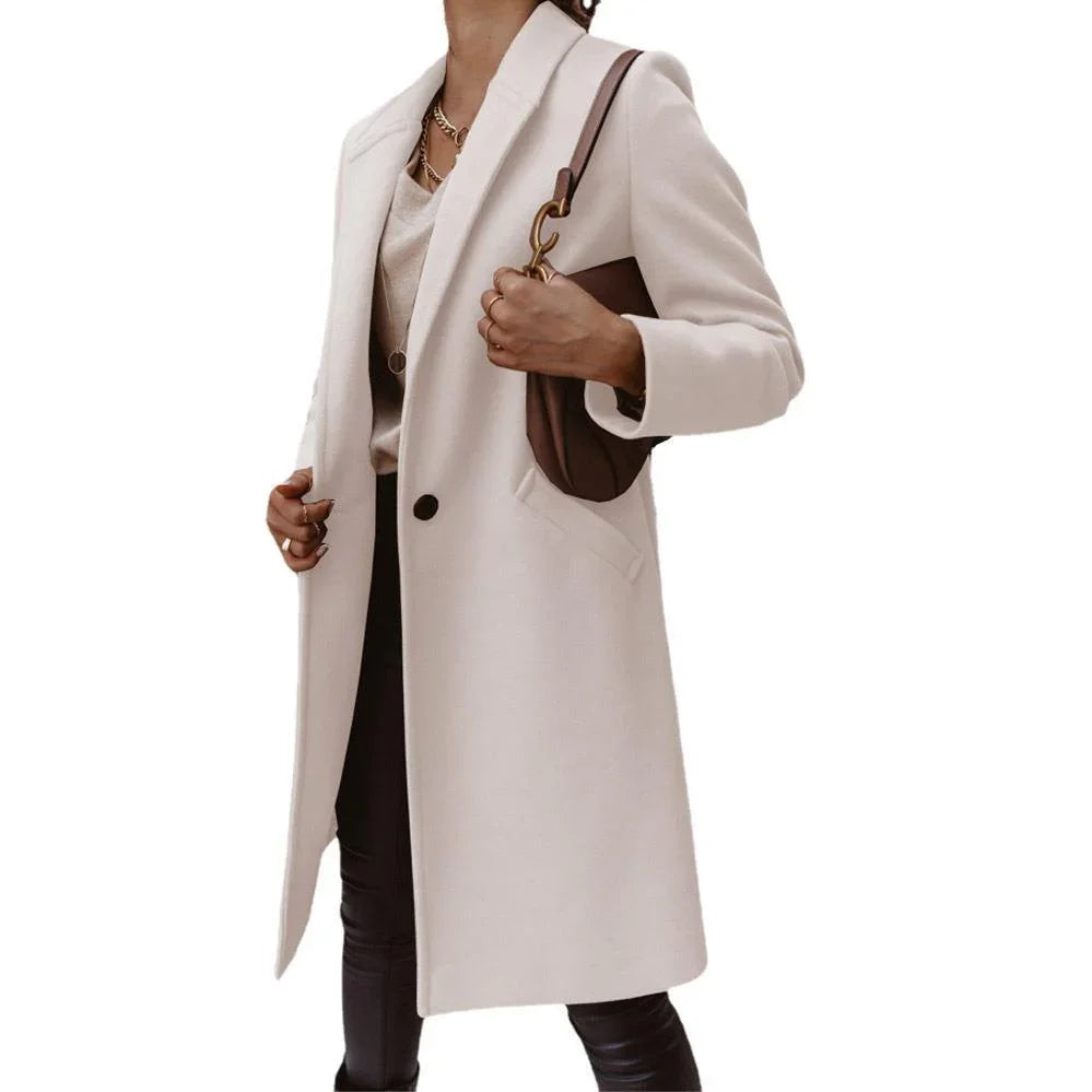 Woman wearing elegant white wool coat, beige top, black pants, and carrying brown leather handbag