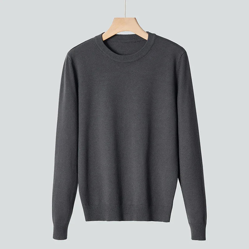 Dark gray crewneck sweater hanging on wooden hanger against light gray background