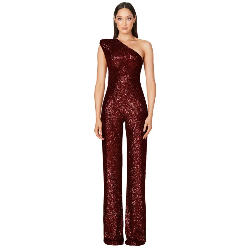 Woman wearing a burgundy one-shoulder sequined jumpsuit with wide-leg pants on white background