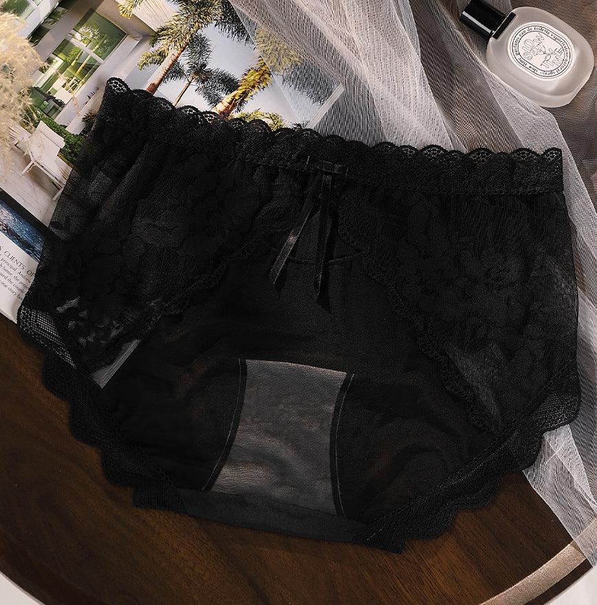 black lace and mesh women's underwear with scalloped edges and small bow detail on wooden surface