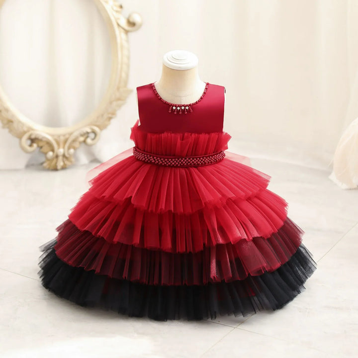 Red and black layered tulle baby girl dress with beaded neckline on mannequin