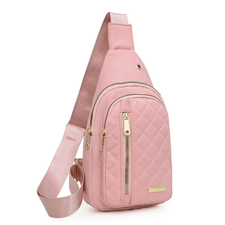 Pink quilted crossbody sling bag with gold zippers and adjustable strap