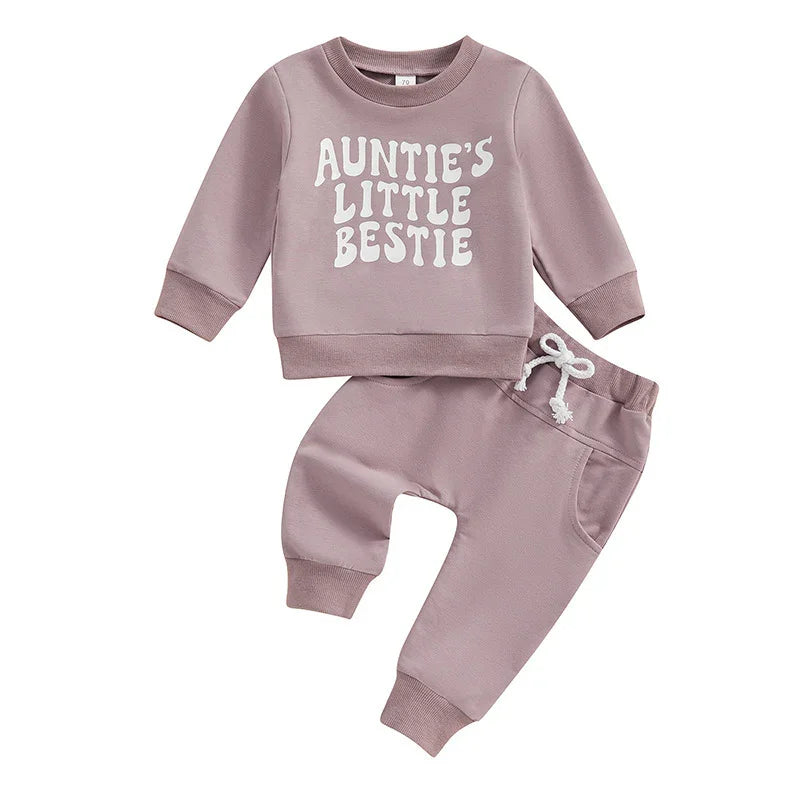 Mauve baby outfit with long-sleeve top reading 'Auntie's Little Bestie' and matching pants with drawstring