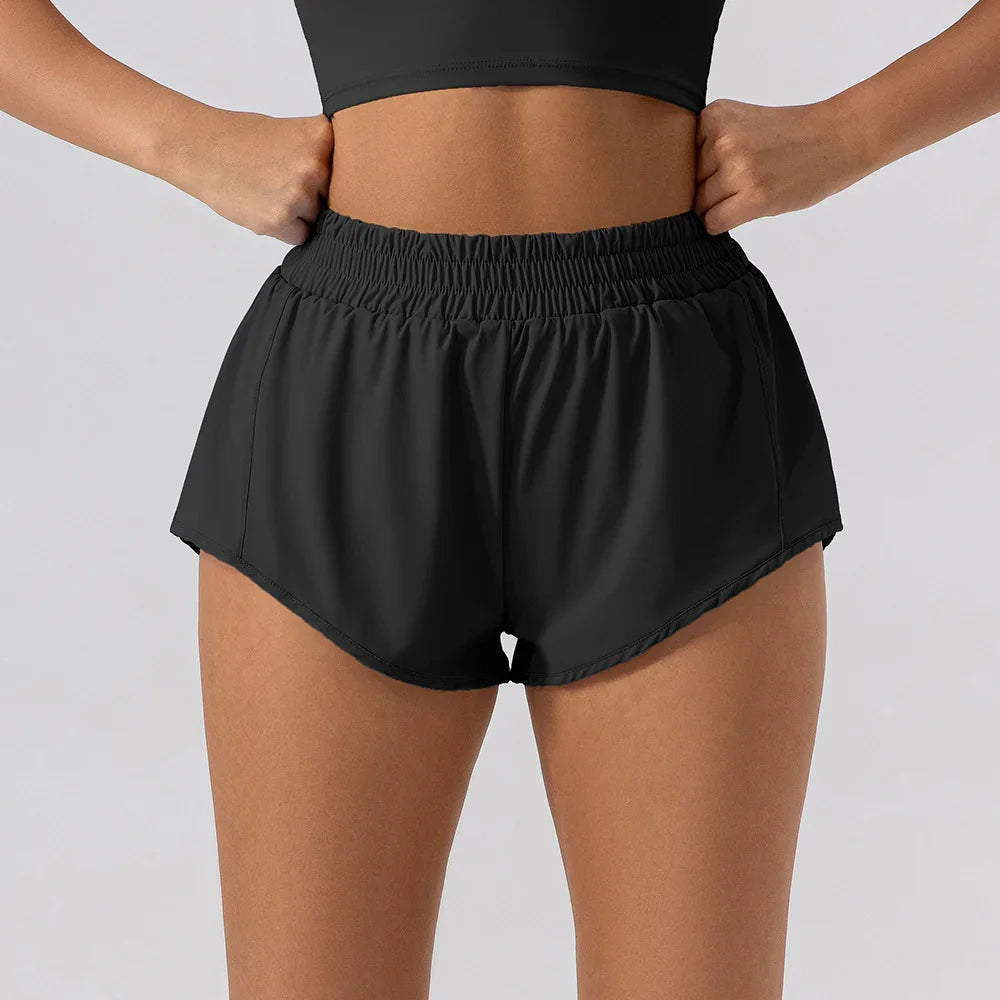 Woman wearing black high-waisted running shorts with elastic waistband and side pockets