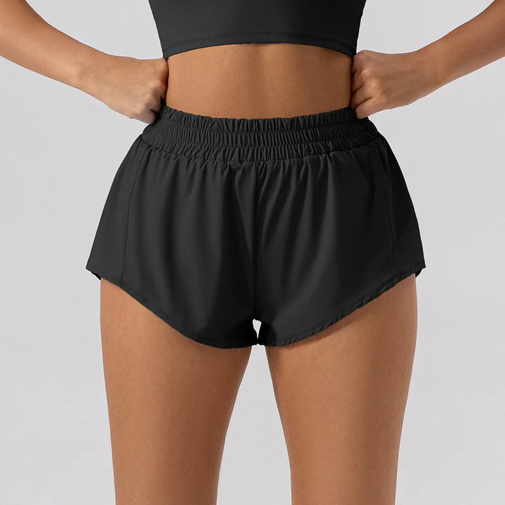 Woman wearing black high-waisted running shorts with elastic waistband and side pockets