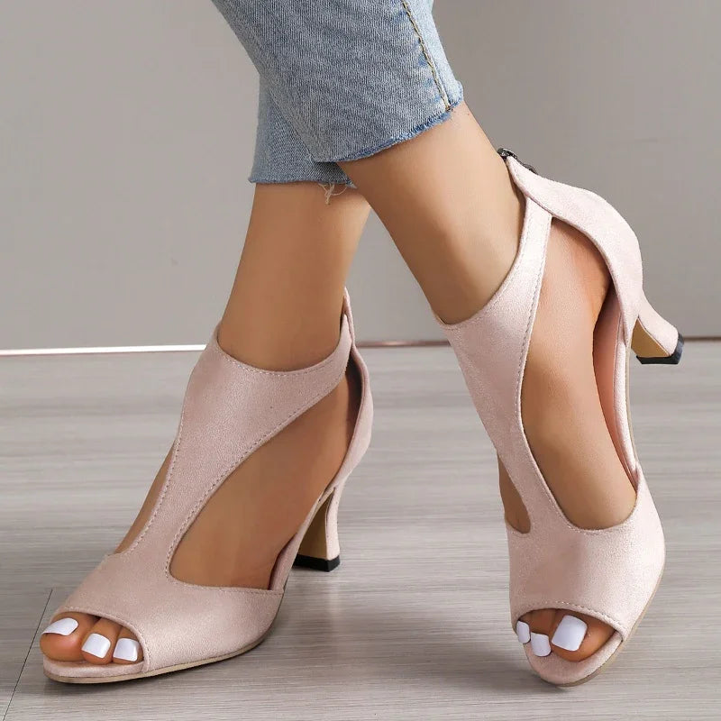 women's light pink open-toe high heel shoes paired with cropped blue jeans on wooden floor