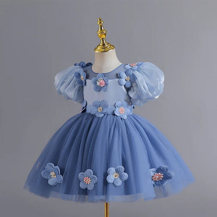 Blue toddler dress with puff sleeves and floral appliques on skirt and bodice, displayed on mannequin
