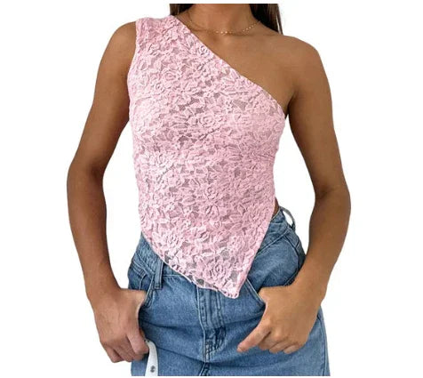 Woman wearing pink lace one-shoulder top with handkerchief hem and blue denim jeans