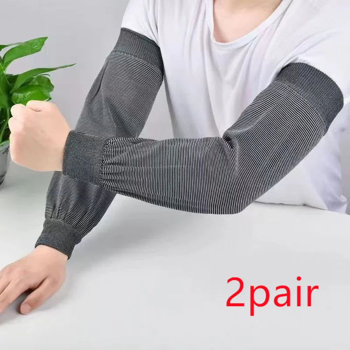 Person wearing black and white striped sleeve protectors on arms over a white shirt, with green plant and text 2 pair