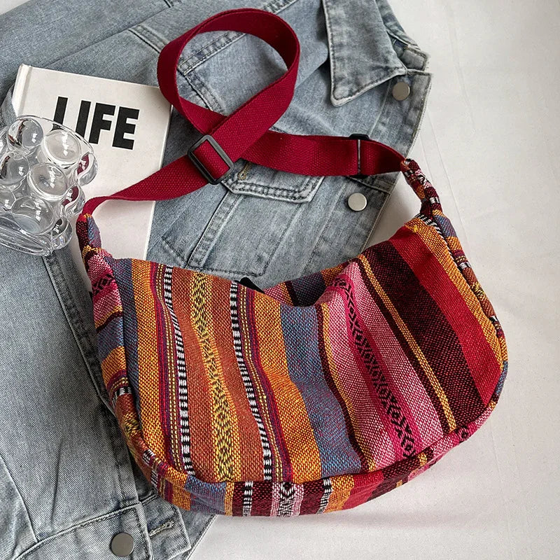 Colorful striped fabric shoulder bag with red adjustable strap on denim jacket and LIFE magazine