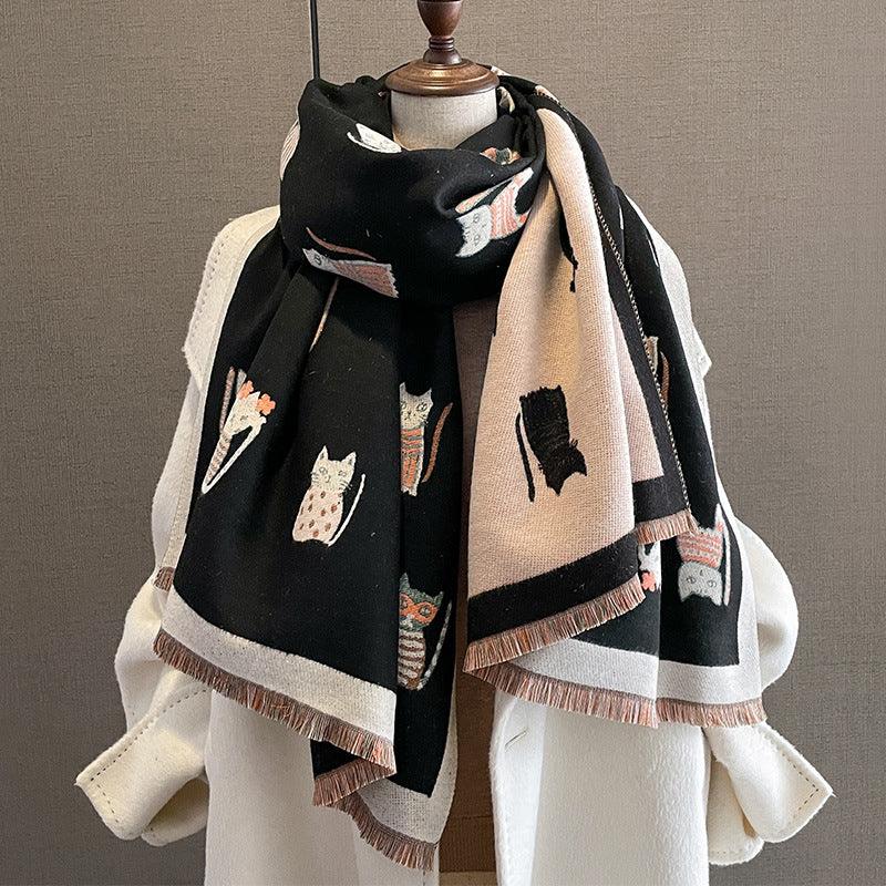 Black and beige knitted scarf with cat patterns displayed on a white mannequin torso