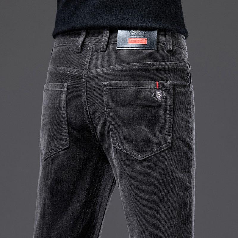 Close-up of black corduroy pants back pockets with red and black branded label on waist