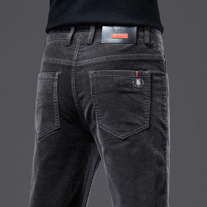Close-up of black corduroy pants back pockets with red and black branded label on waist