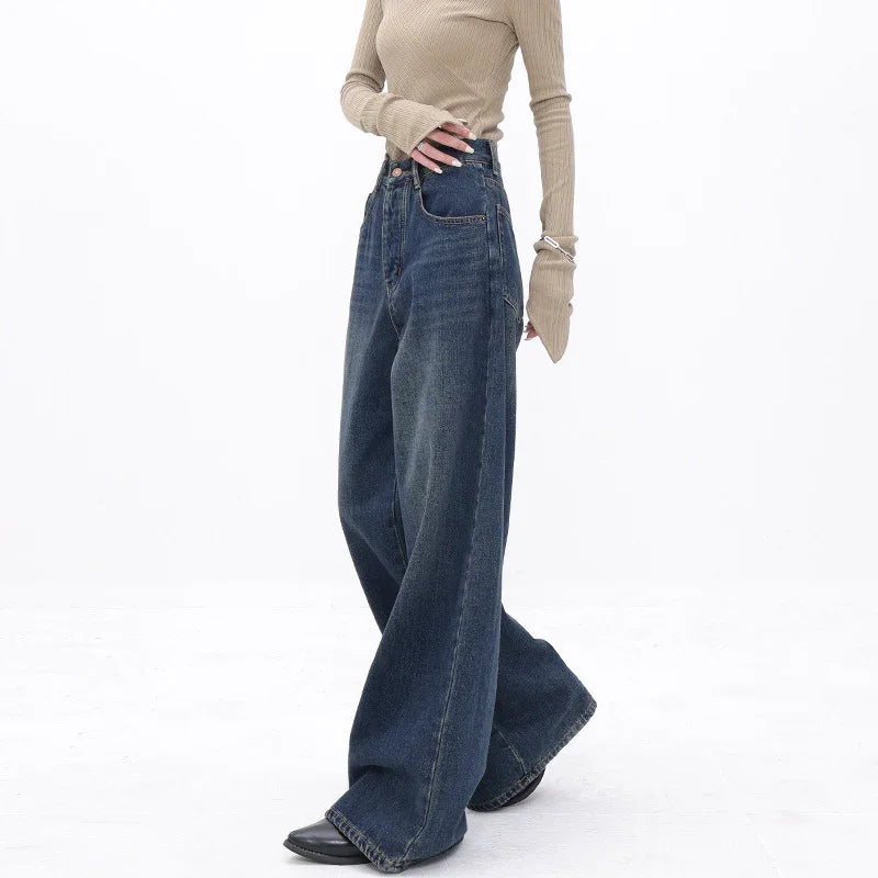 Woman wearing high-waisted wide leg dark blue jeans with beige ribbed long sleeve top