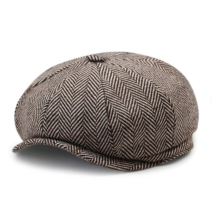 brown and beige herringbone patterned newsboy cap with small brim on white background