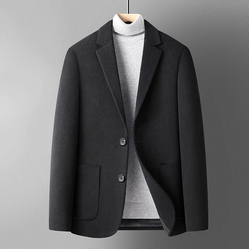 Black wool blazer jacket layered over light gray turtleneck sweater on hanger