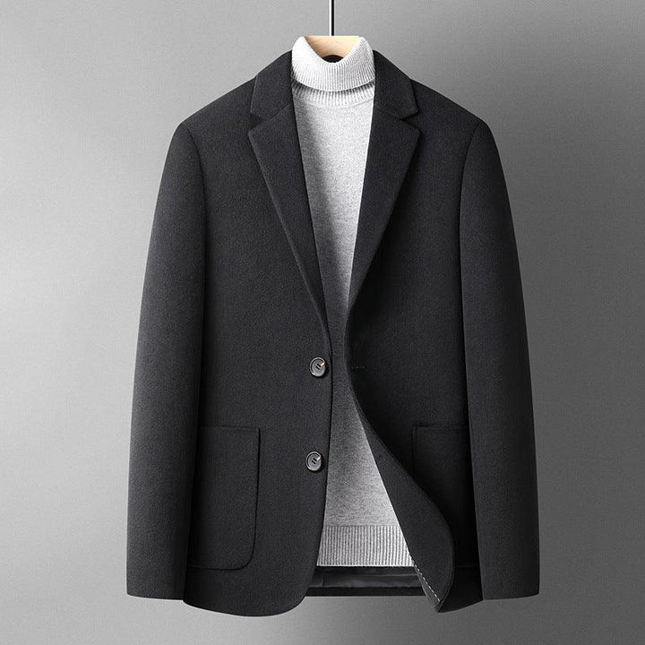 Black wool blazer jacket layered over light gray turtleneck sweater on hanger