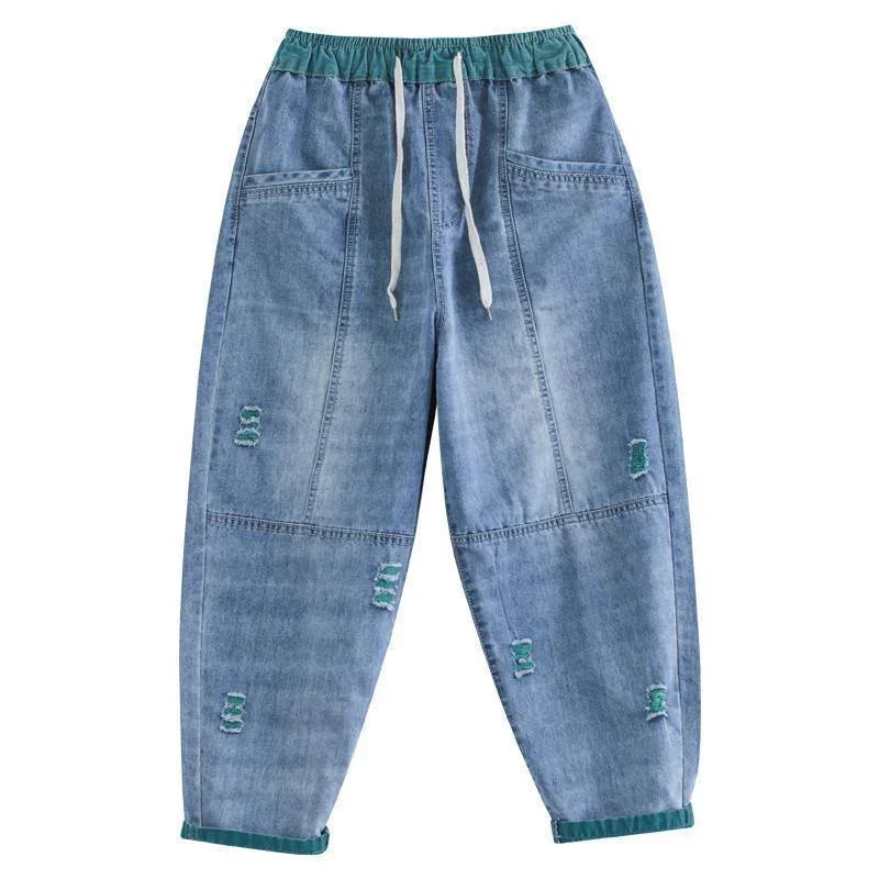 blue denim jogger pants with green elastic waistband and hems, white drawstrings, and distressed patches