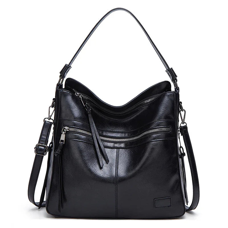 Black leather handbag with dual handles, front zipper pocket, and detachable shoulder strap