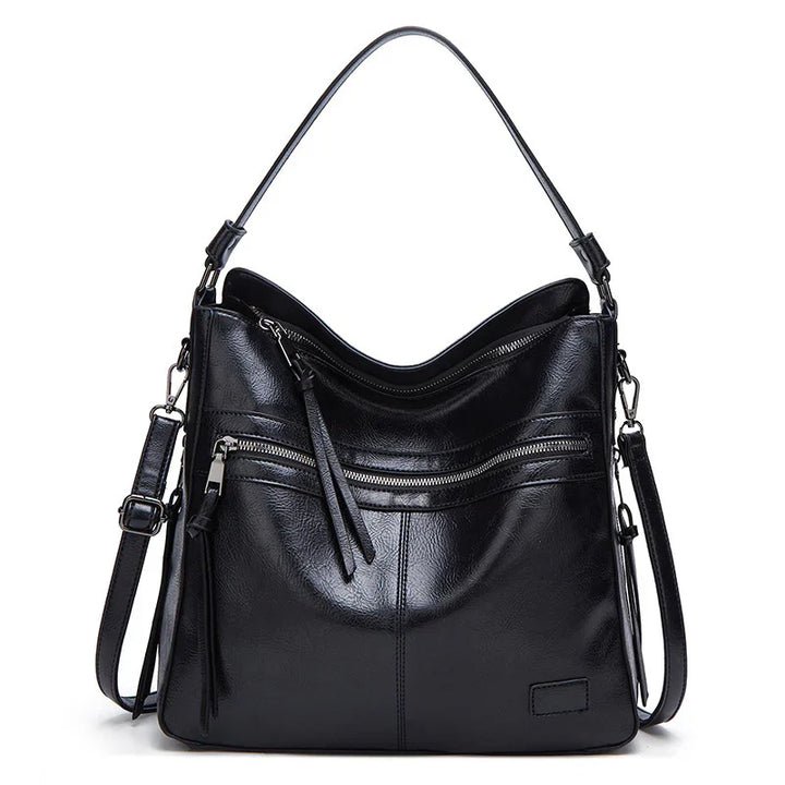 Black leather handbag with dual handles, front zipper pocket, and detachable shoulder strap