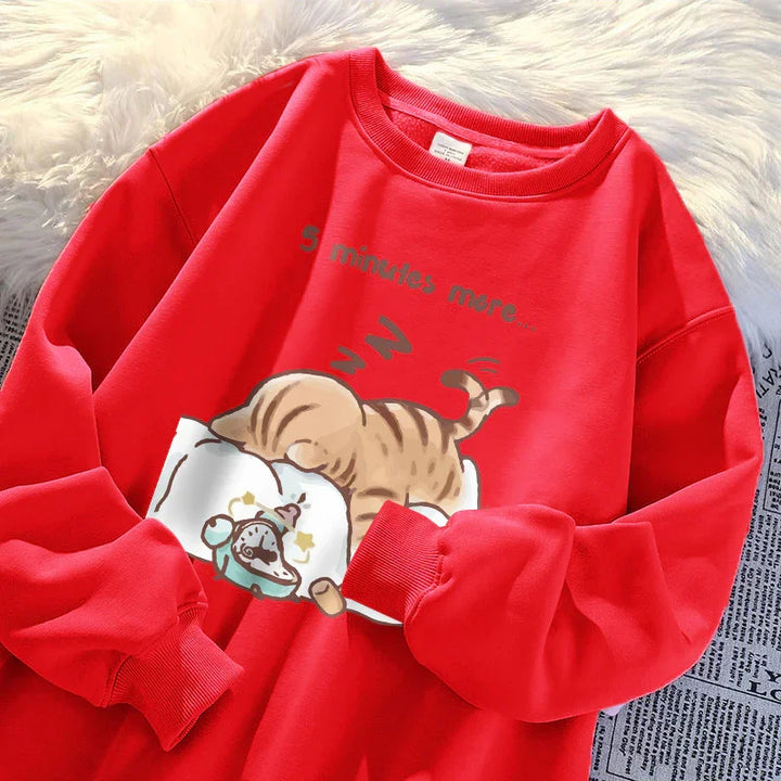 Red sweatshirt with a cartoon cat sleeping on a pillow and text reading '5 minutes more'
