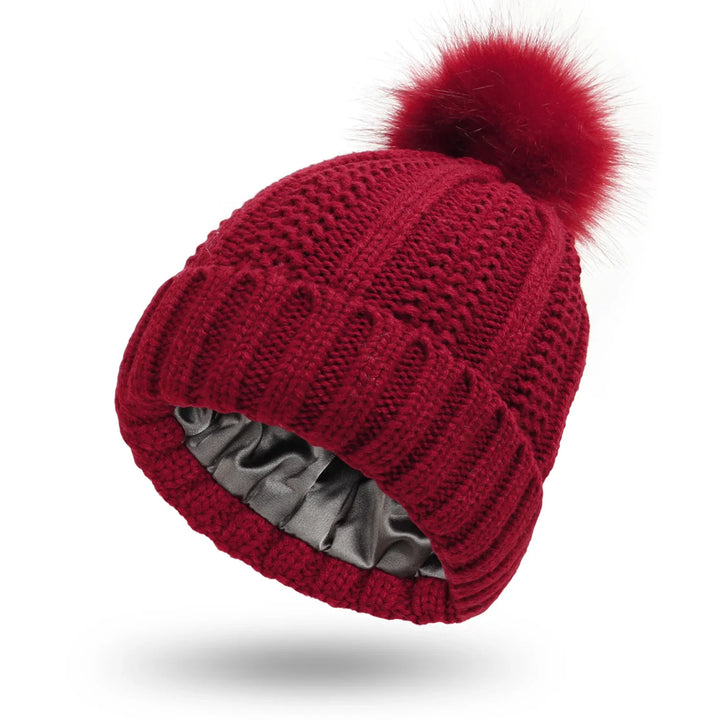 Red knitted winter beanie with faux fur pom-pom and satin lining