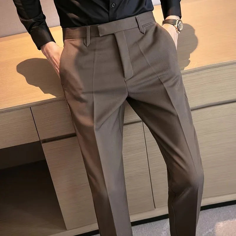 close-up of man wearing brown tailored dress pants with hands in pockets and black shirt