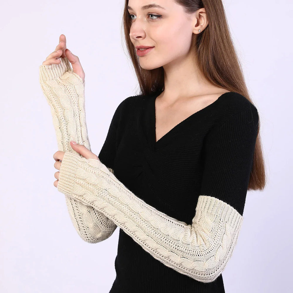 Young woman wearing black sweater with beige cable knit arm warmers on white background