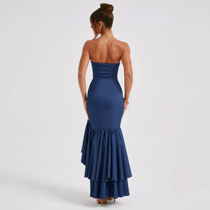 Back view of woman in strapless navy blue mermaid evening gown with ruffled layered skirt