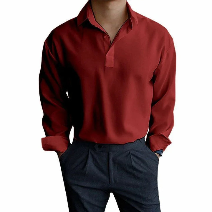 Man wearing a long sleeve red polo shirt with rolled cuffs and dark grey pleated pants